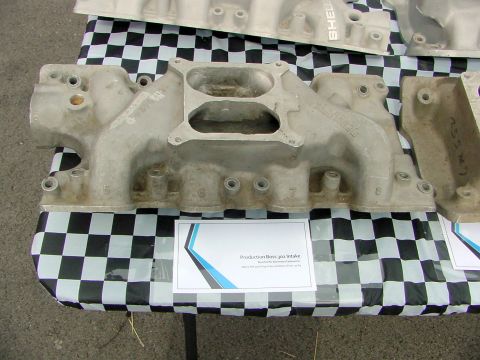 1969 Ford Mustang - Close-up of a Ford Boss 302 intake manifold, likely for a Mustang, displayed on a table.