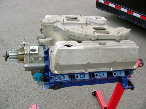 1969 Ford Mustang - A 1969 Ford Mustang Boss 302 intake manifold and valve covers are displayed on a red engine stand.