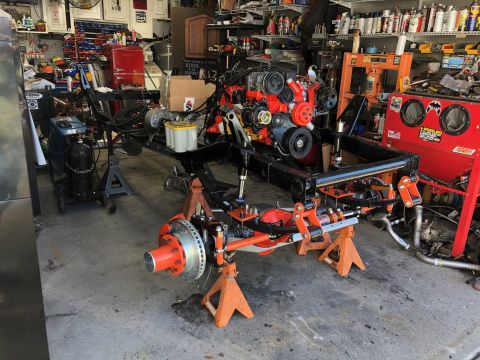 1992 Jeep Wrangler - A vehicle's frame and engine are disassembled and supported by jack stands in a workshop.