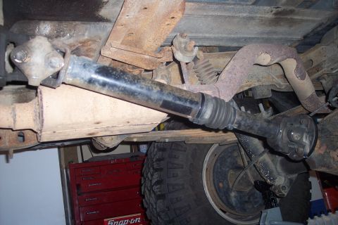 1995 Ford Bronco - Underside view of a vehicle's driveshaft and exhaust components, with a red toolbox in the background.