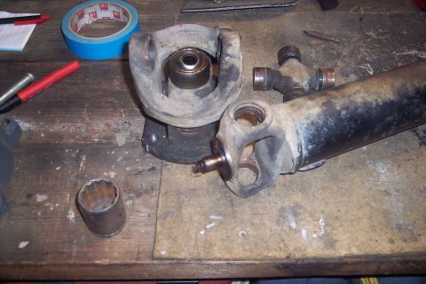 1995 Ford Bronco - Parts for a driveshaft, including universal joints and a socket, are laid out on a workbench.