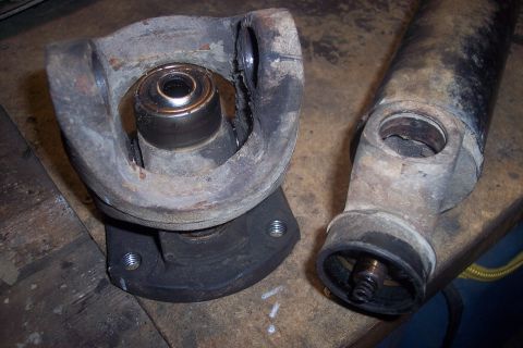 1995 Ford Bronco - Close-up of a disassembled driveshaft U-joint and yoke, showing wear and damage.