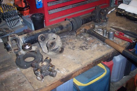 1995 Ford Bronco - Driveshaft components and tools laid out on a workbench.