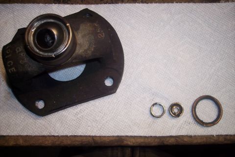 1995 Ford Bronco - A driveshaft part with a bearing and three rings is laid out on a white cloth.