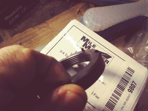 1996 Ford Bronco - A hand holds a threaded nut over packaging that includes text and a barcode.