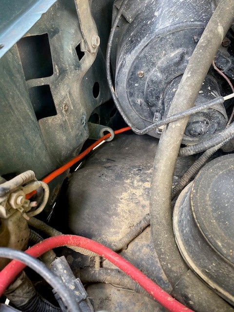 1996 Ford Bronco - Close-up view of the engine bay, showing a red wire passing through a rubber grommet.