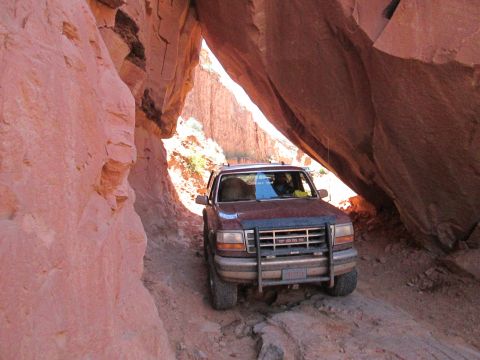1992 Ford Bronco - Ford Bronco driving through a tight slot canyon on an off-road trail.