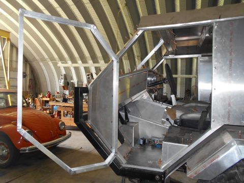 1992 Ford Bronco - Interior of a custom-built vehicle under construction, with an orange car visible in the background.