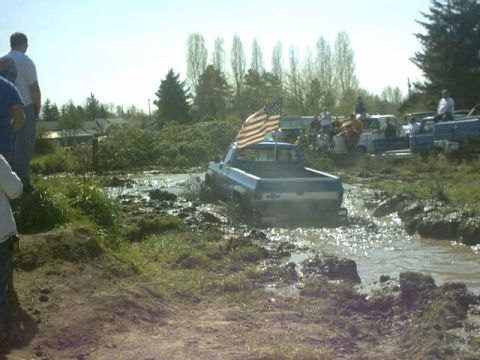 1995 Ford Bronco - Truck stuck in mud pit with American flag flying.