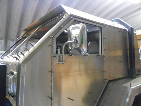 1992 Ford Bronco - Unfinished vehicle body shows exposed metal construction and a chrome side mirror, with interior seats visible through the window.