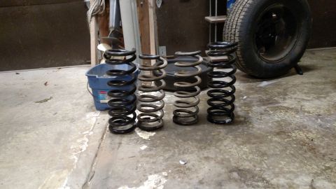 1979 Chevrolet Camaro - Collection of four automotive coil springs displayed on a garage floor.