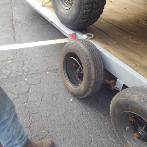 1990 Ford F-250 - A trailer with multiple tires is parked on asphalt, with one tire appearing to be flat.