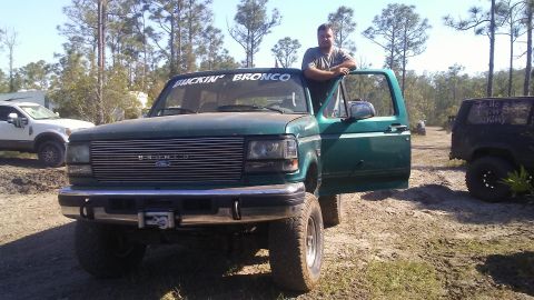 1996 Ford Bronco - A man poses with his lifted green Ford Bronco, which has a winch on the front bumper.
