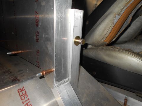 1992 Ford Bronco - Close-up of a vehicle's interior, showing a worn seat and metal structural components with stamped markings.