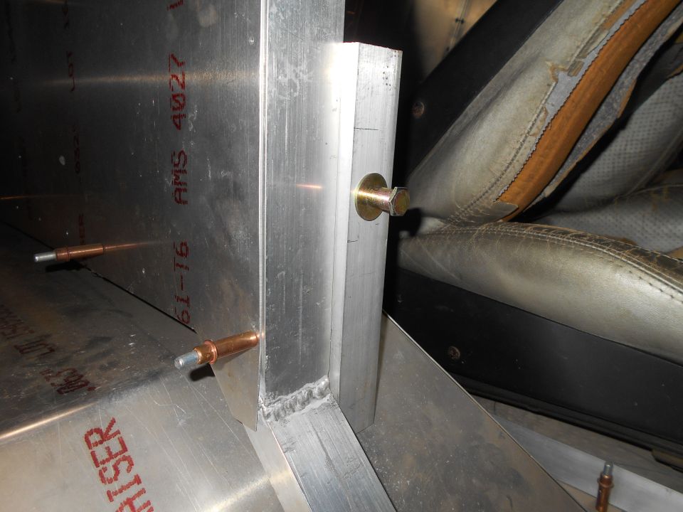 Interior view of a vehicle seat and metal bracing with visible text