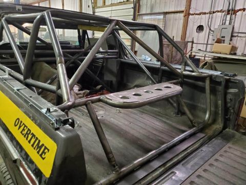 1978 Ford Bronco - A custom roll cage is installed in the bed of a truck, with a yellow 'OVERTIME' sticker visible.