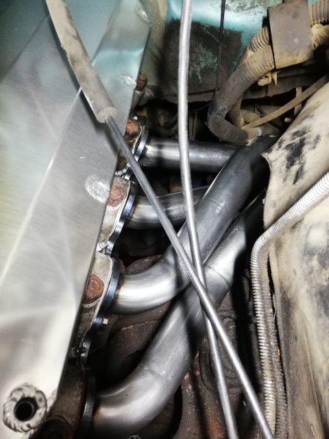 1996 Ford Bronco - Close-up view of a newly installed engine exhaust manifold with shiny pipes.