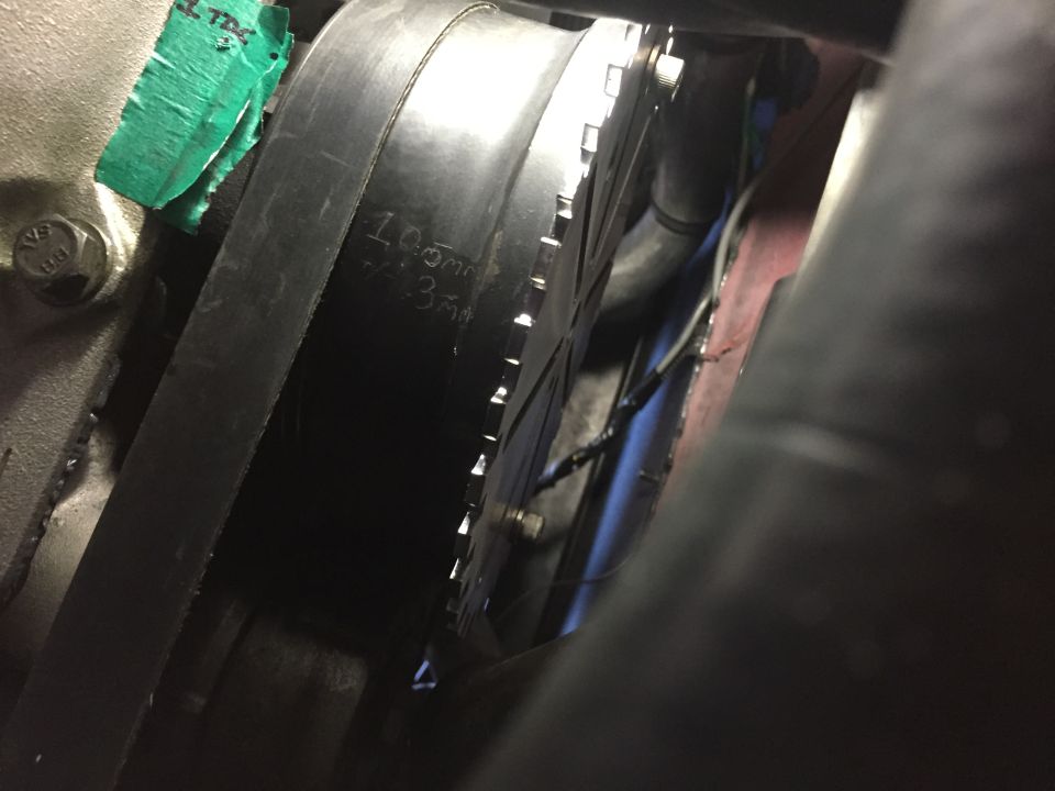 Engine timing belt with markings '100mm' and '35mm' visible on pulley. Green tape marked 'TDC' is on engine block