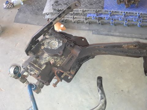 1994 Ford Bronco - A close-up view of a rusty steering gear box and a section of vehicle frame, with a pressure gauge attached.