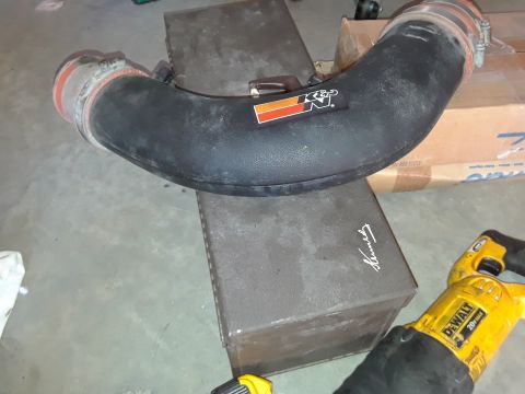 1994 Ford Bronco - K&N air intake tube and a DeWalt saw are on a box in a garage.
