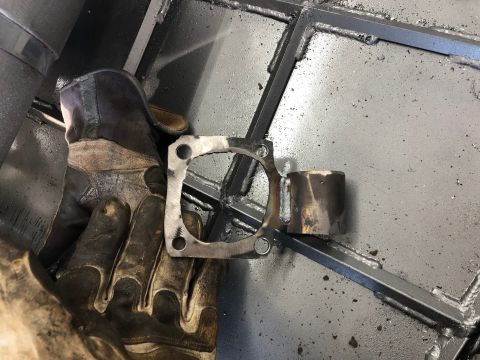 1992 Jeep Wrangler - A metal part is being welded, held by a gloved hand over a metal grid.
