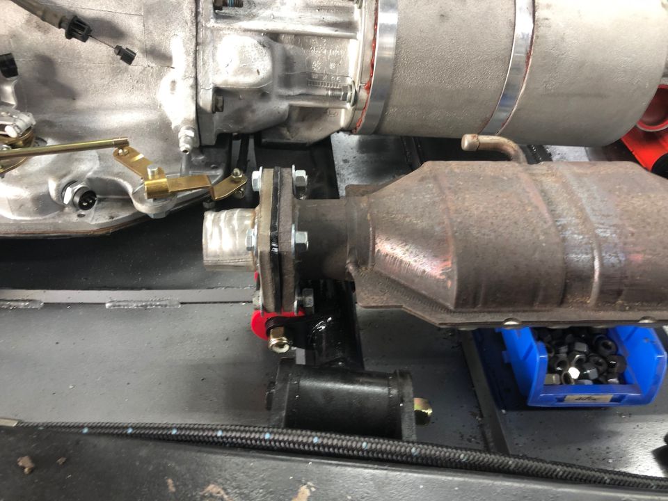Exhaust system catalytic converter and transmission linkage