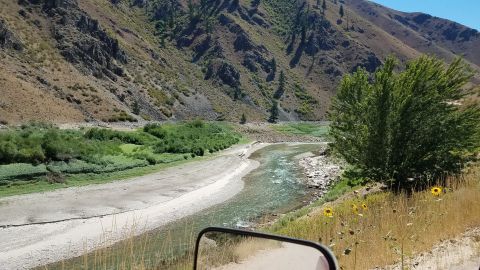 1985 Ford Bronco - A scenic view of a river valley, seen from the perspective of a vehicle's side mirror.