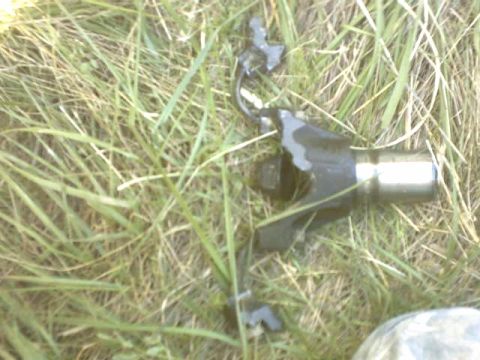 1995 Ford Bronco - A broken driveshaft part rests on the grass, indicating a vehicle malfunction.