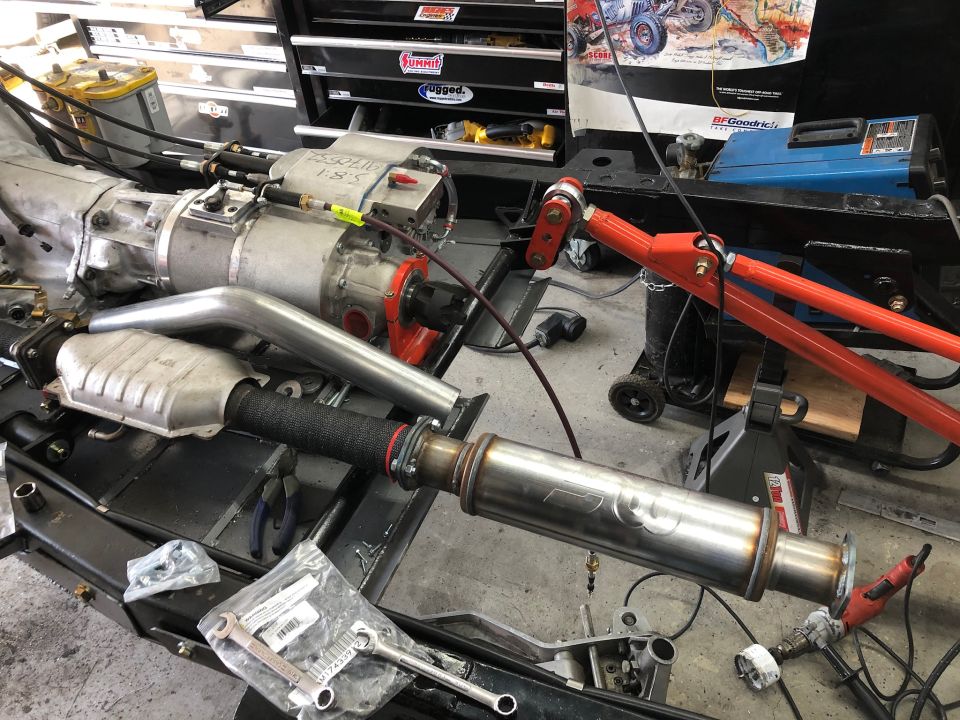 Vehicle exhaust system with catalytic converter and muffler, alongside transmission components