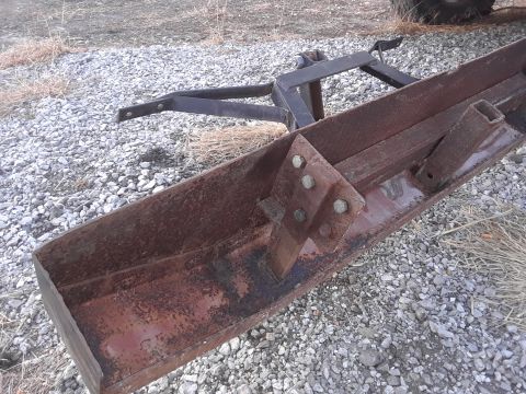 1994 Ford Bronco - A close-up view of a rusted metal implement, likely a piece of farm equipment, on a gravel surface.