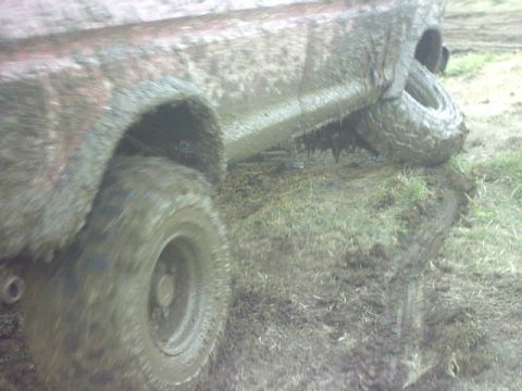 1995 Ford Bronco - This 1995 Ford Bronco is seen from the side, heavily covered in mud and appears to be stuck in a muddy ditch.