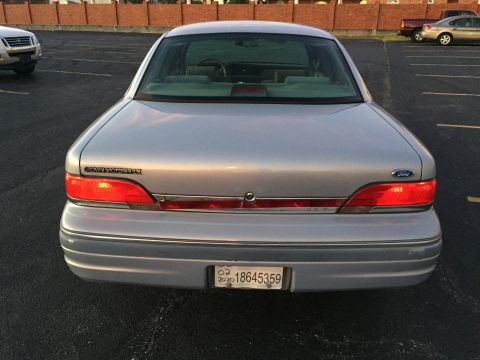 1994 Ford Crown Victoria - Rear view of a silver sedan, possibly a 1995 model, with "Crown Victoria" text visible on the trunk.