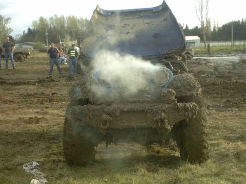 1995 Ford Bronco - Muddy vehicle steaming with hood open, people watching in the background.