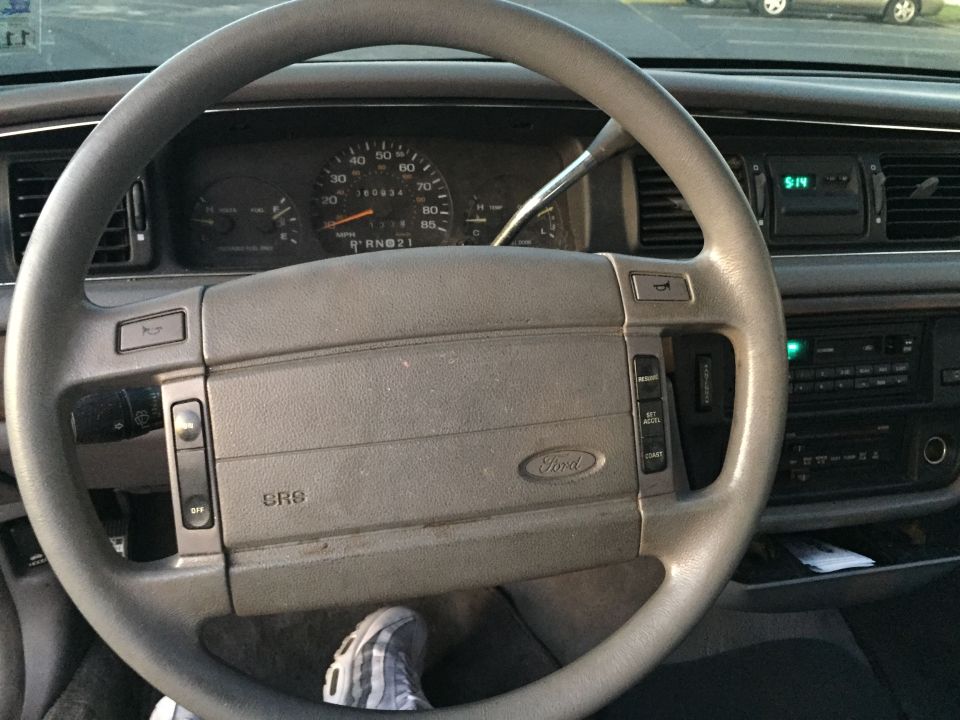 Interior shot of a 1994 Ford Crown Victoria showing the steering wheel, dashboard, and radio