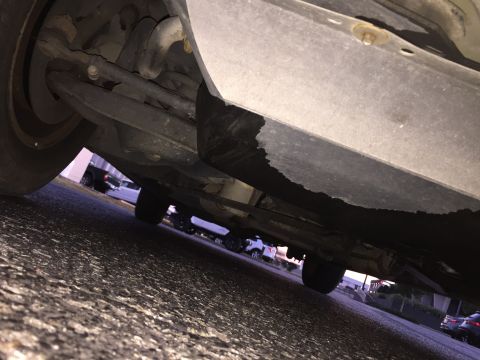 1994 Ford Crown Victoria - A low-angle shot shows the undercarriage of a vehicle, with multiple other vehicles visible in the background.