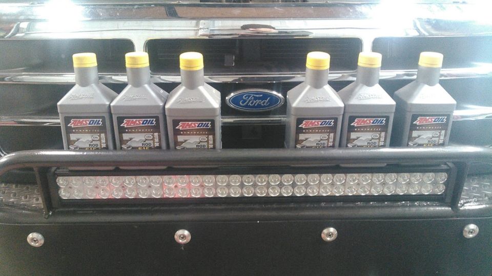 Ford grille with six bottles of AMSOIL oil and an LED light bar mounted on a bull bar