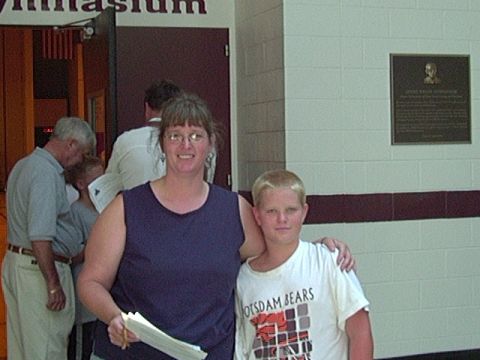 1978 Ford Bronco - A woman and a boy stand in front of a gymnasium entrance with a plaque on the wall.