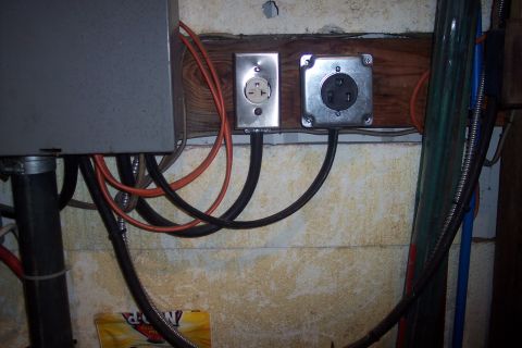 1995 Ford Bronco - Close-up of electrical wiring and outlets on a wall, with a metal panel on the left.