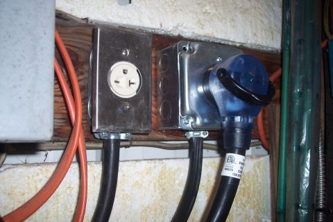 1995 Ford Bronco - Electrical outlets and plugs with attached cables are mounted on a wooden surface.