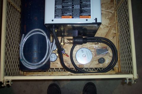 1995 Ford Bronco - Welding machine, gas cylinder, and various accessories are organized within a wire cage.