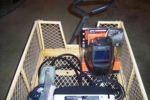 1995 Ford Bronco - Welding equipment, including a helmet and grinder, is organized within a wire cart.