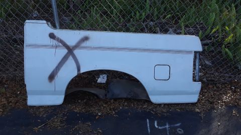 1994 Ford Bronco - A white rear quarter panel, marked with a large X, is shown from the side, revealing a fuel door and taillight area.