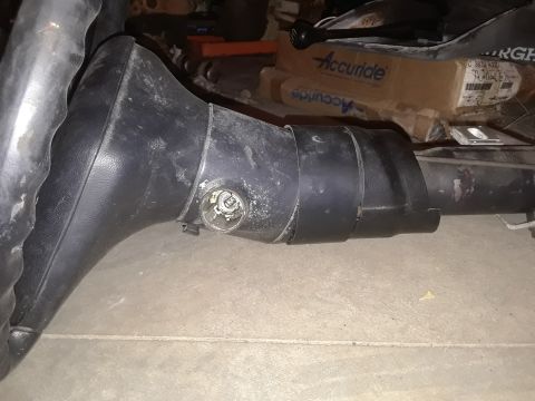 1994 Ford Bronco - A black steering column with the ignition cylinder exposed is shown, likely a salvaged part.