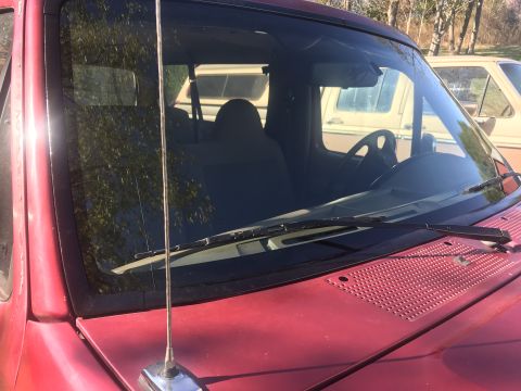 1994 Ford Bronco - Interior view of a red SUV, showing seats and steering wheel, with a white SUV in the background.