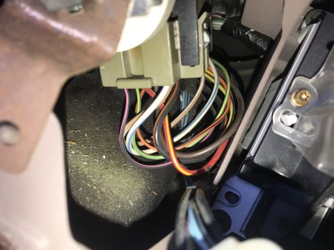 1994 Ford Bronco - Close-up view of a complex wiring harness located beneath the dashboard of a vehicle.