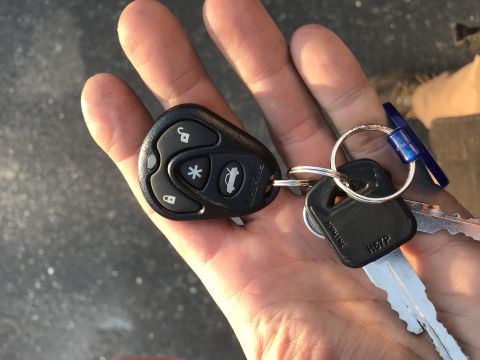 1994 Ford Bronco - Key fob and keys held in a hand. The fob has lock, unlock, trunk, and panic buttons.