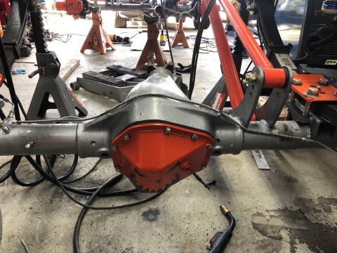 1992 Jeep Wrangler - Rear differential assembly, likely undergoing maintenance or modification, is supported by jack stands in a workshop setting.