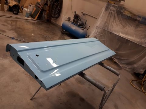 1996 Ford Bronco - A light blue tailgate is mounted on a stand in a workshop, ready for further work.