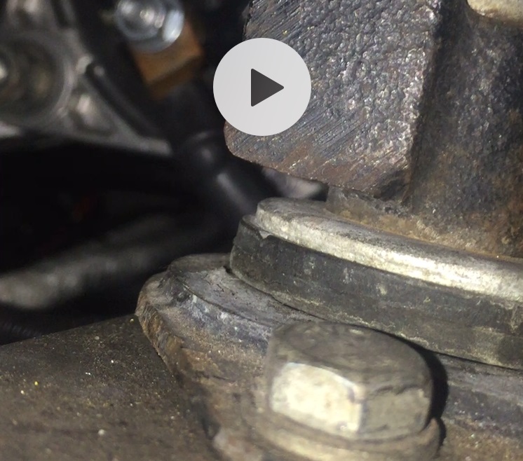 Close-up of a metal engine component with a bolt and washer
