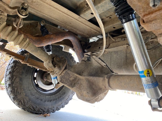 Underside of a vehicle showing differential, leaf springs, and Bilstein shock absorber.
